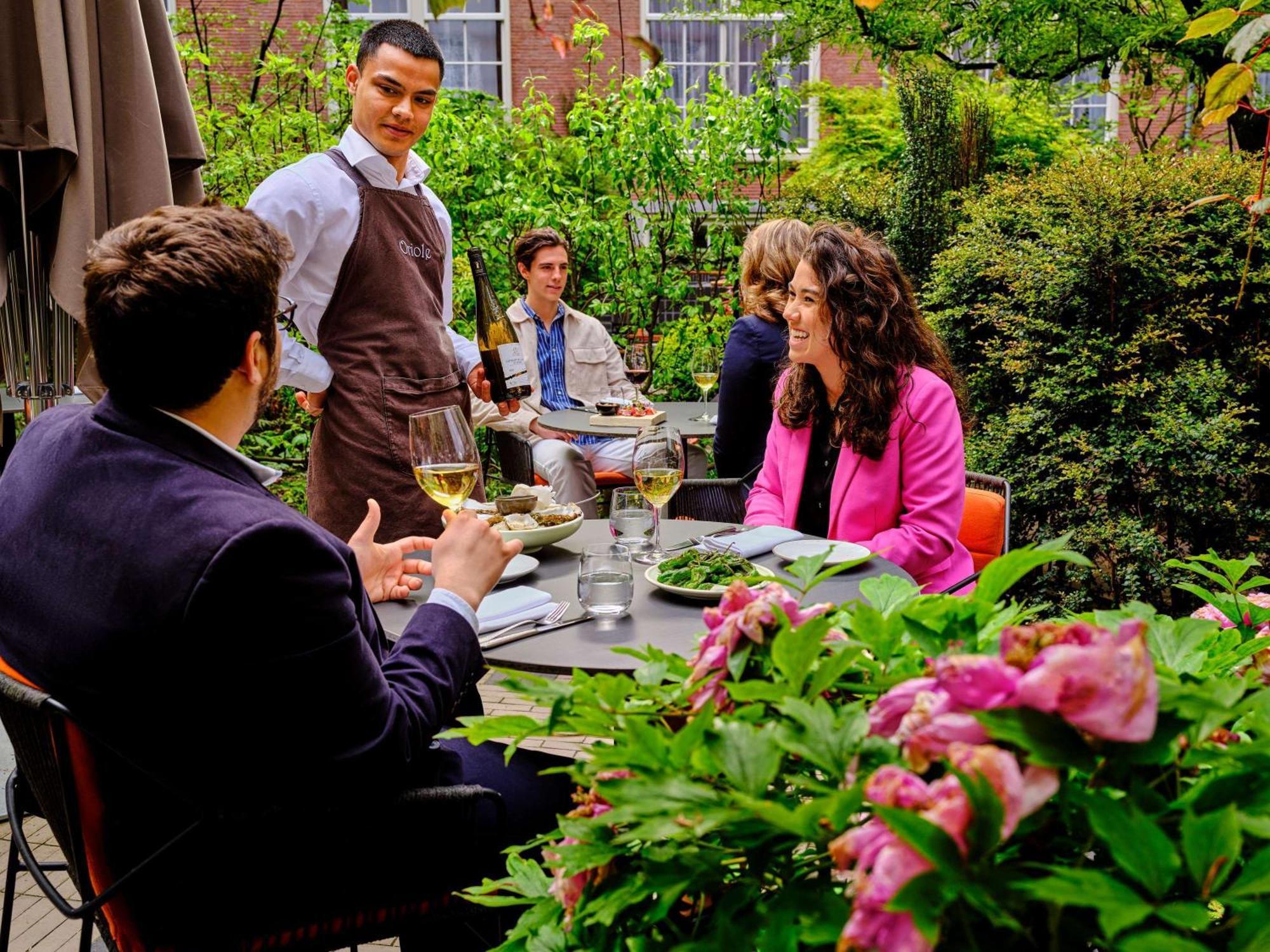 Sofitel Legend The Grand Amsterdam Hotel Exterior photo A waiter serving guests at a restaurant